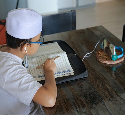 Learn Quran online with expert tutors at Al Quran Online Academy. A young Muslim student studying the Holy Quran via virtual classes. Interactive, personalized Islamic education for kids and adults.